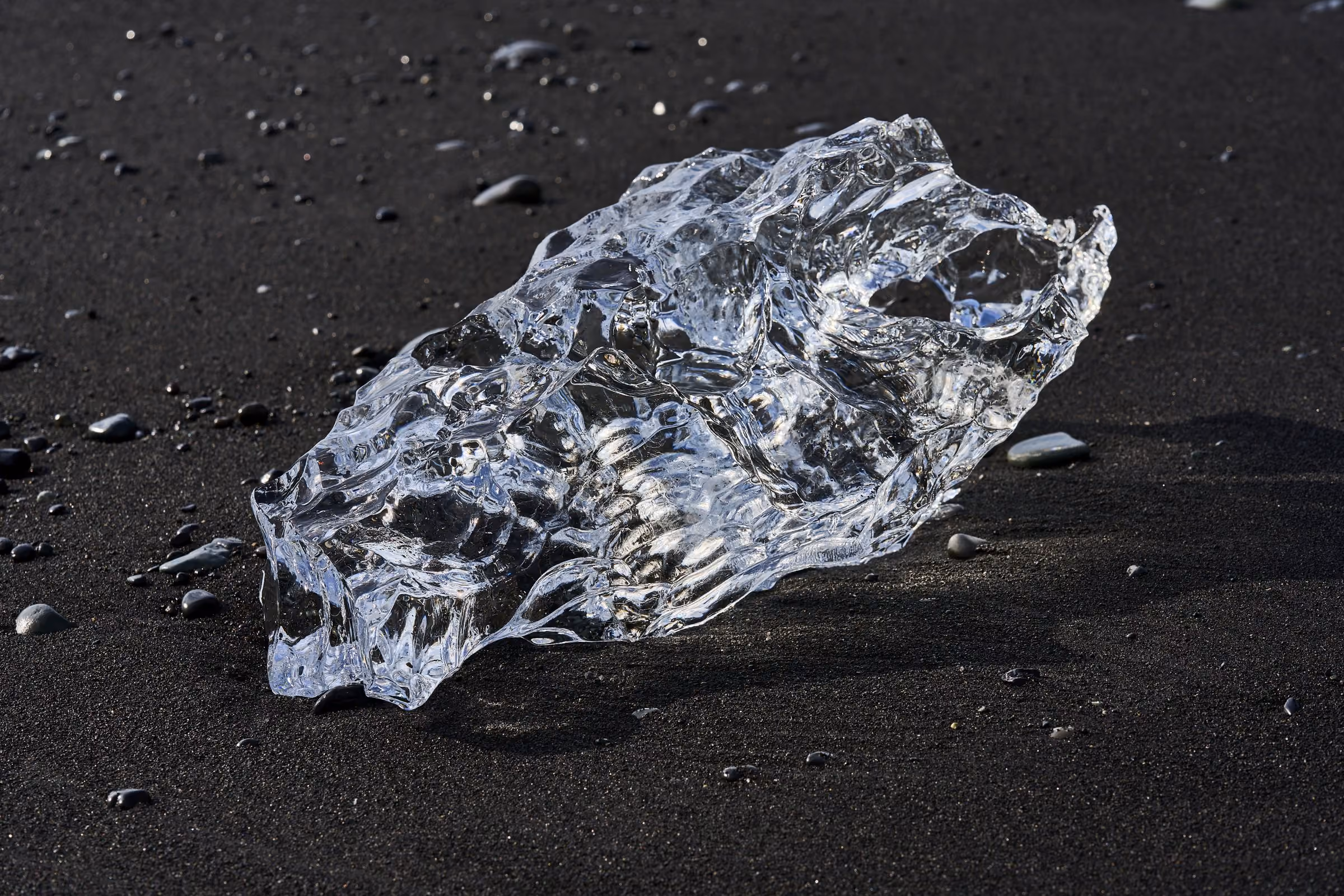 Klares Eis auf schwarzem Sand