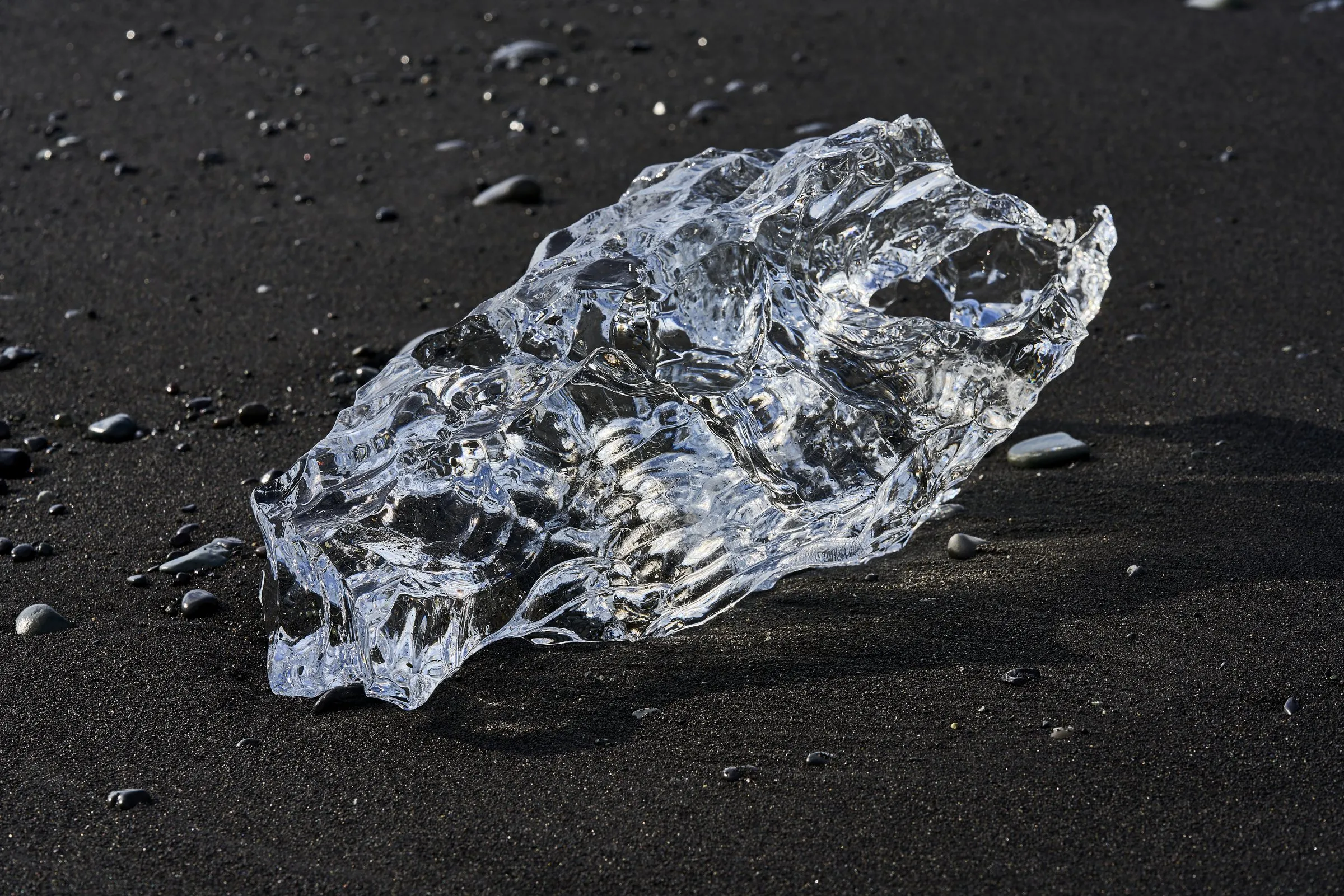 Klares Eis auf schwarzem Sand