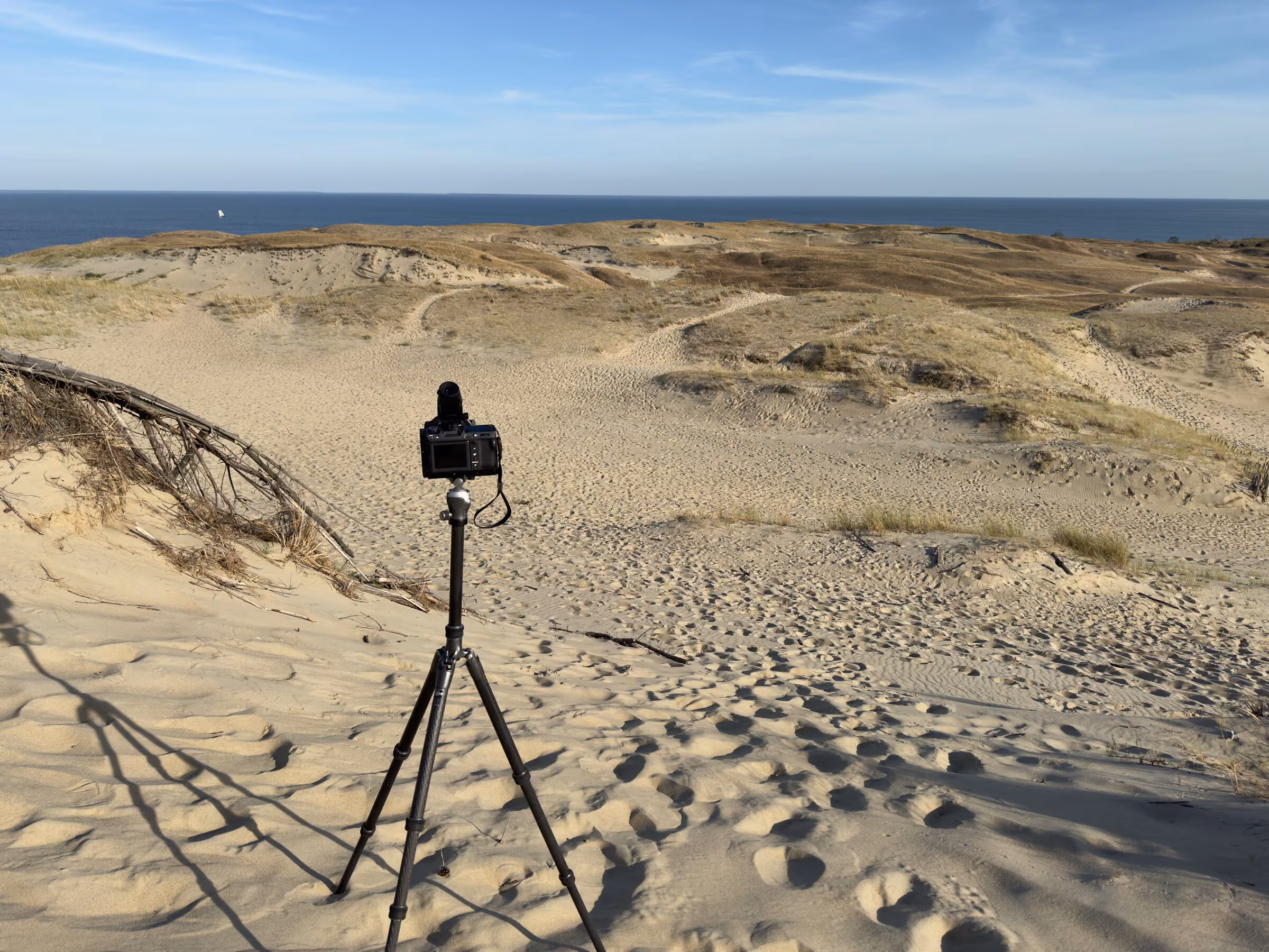 Kamera auf dem Stativ in der Düne, dahinter das Meer